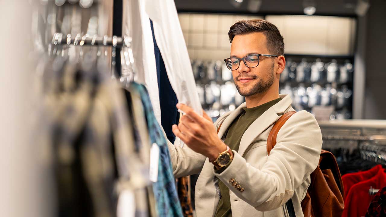 Hombre comprando ropa y mirando etiquetas